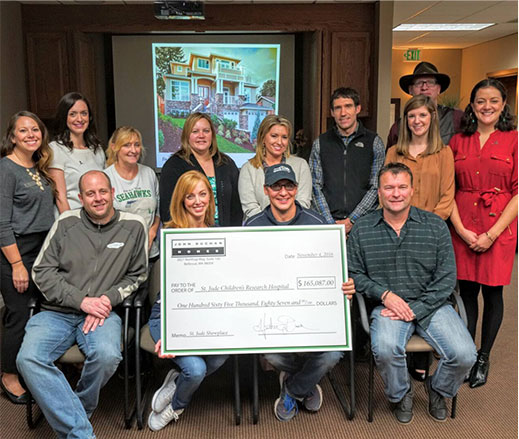 Giving back to the community - a group of people holding a big check